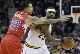 Cleveland Cavaliers' LeBron James (23) looks for a teammate under pressure from Los Angeles Clippers Matt Barnes (22) during an NBA basketball game Thursday, Feb. 5, 2015, in Cleveland. (AP Photo/Tony Dejak)