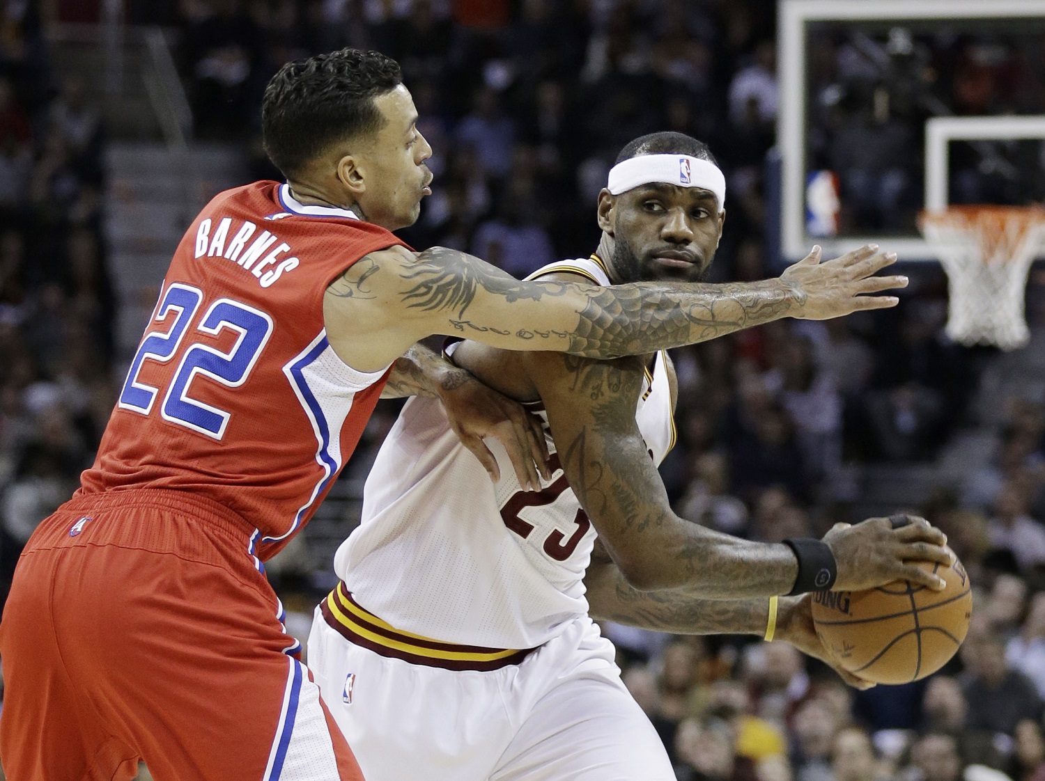 Cleveland Cavaliers' LeBron James (23) looks for a teammate under pressure from Los Angeles Clippers Matt Barnes (22) during an NBA basketball game Thursday, Feb. 5, 2015, in Cleveland. (AP Photo/Tony Dejak)