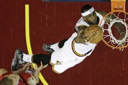 Cleveland Cavaliers' LeBron James, right, dunks the ball in front of Los Angeles Clippers Blake Griffin (32) in the first half of an NBA basketball game Thursday, Feb. 5, 2015, in Cleveland. (AP Photo/Tony Dejak)