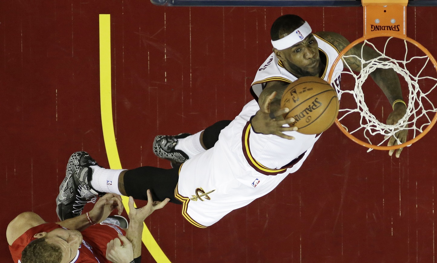 Cleveland Cavaliers' LeBron James, right, dunks the ball in front of Los Angeles Clippers Blake Griffin (32) in the first half of an NBA basketball game Thursday, Feb. 5, 2015, in Cleveland. (AP Photo/Tony Dejak)