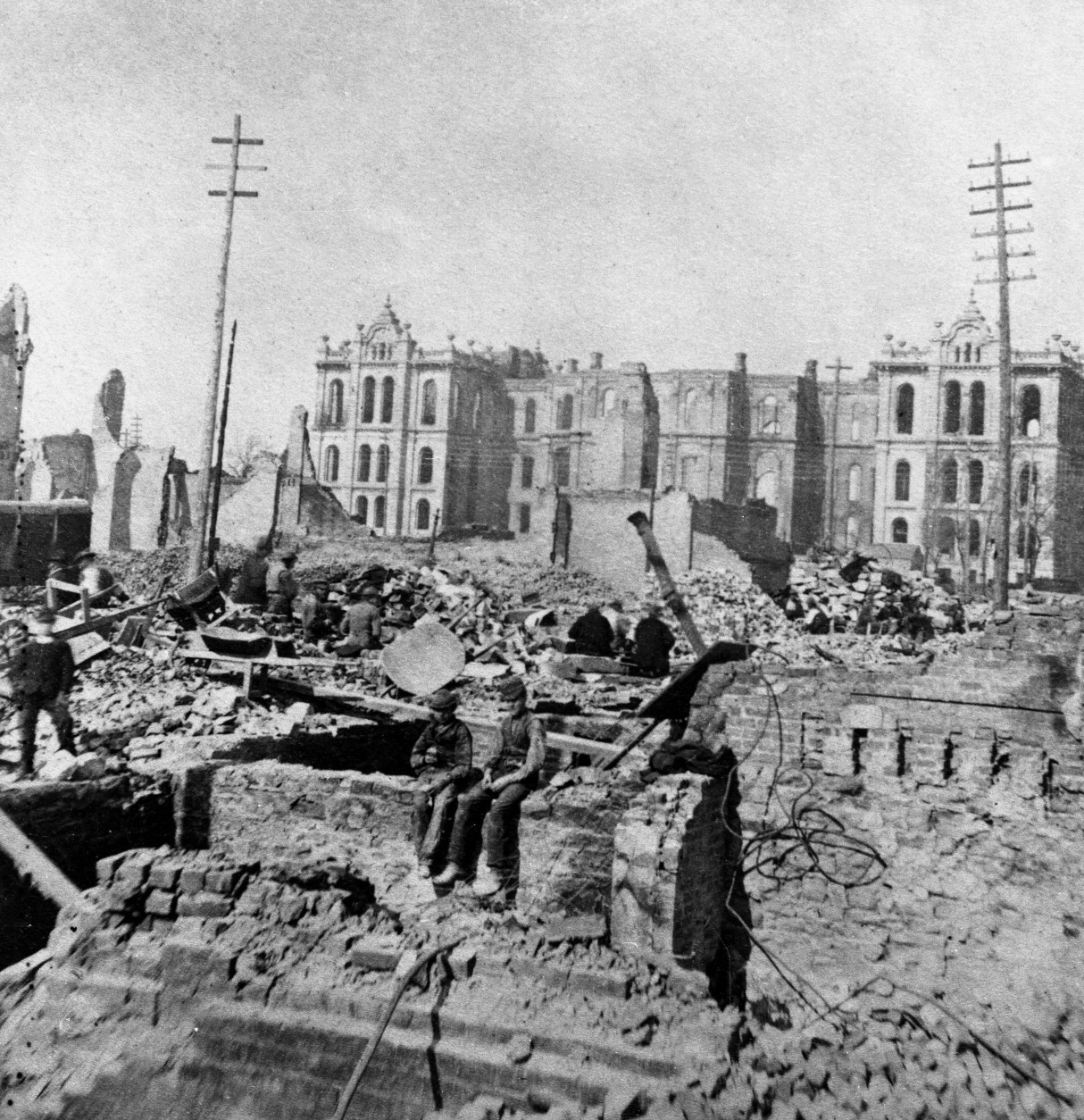 Two boys sit on top of a partial stone wall in the wreckage of a burned-out building at Madison and Clark Streets, with the Court House in the background following the great Chicago fire of October 8 - 10, 1871, Chicago, Illinois. (Photo by Hulton|Archive/Getty Images)