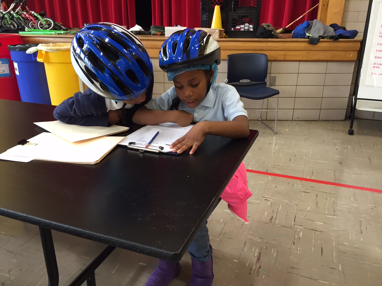 Two CW Harris Elementary School students check out some paperwork before the big event. (WTOP/Kate Ryan)