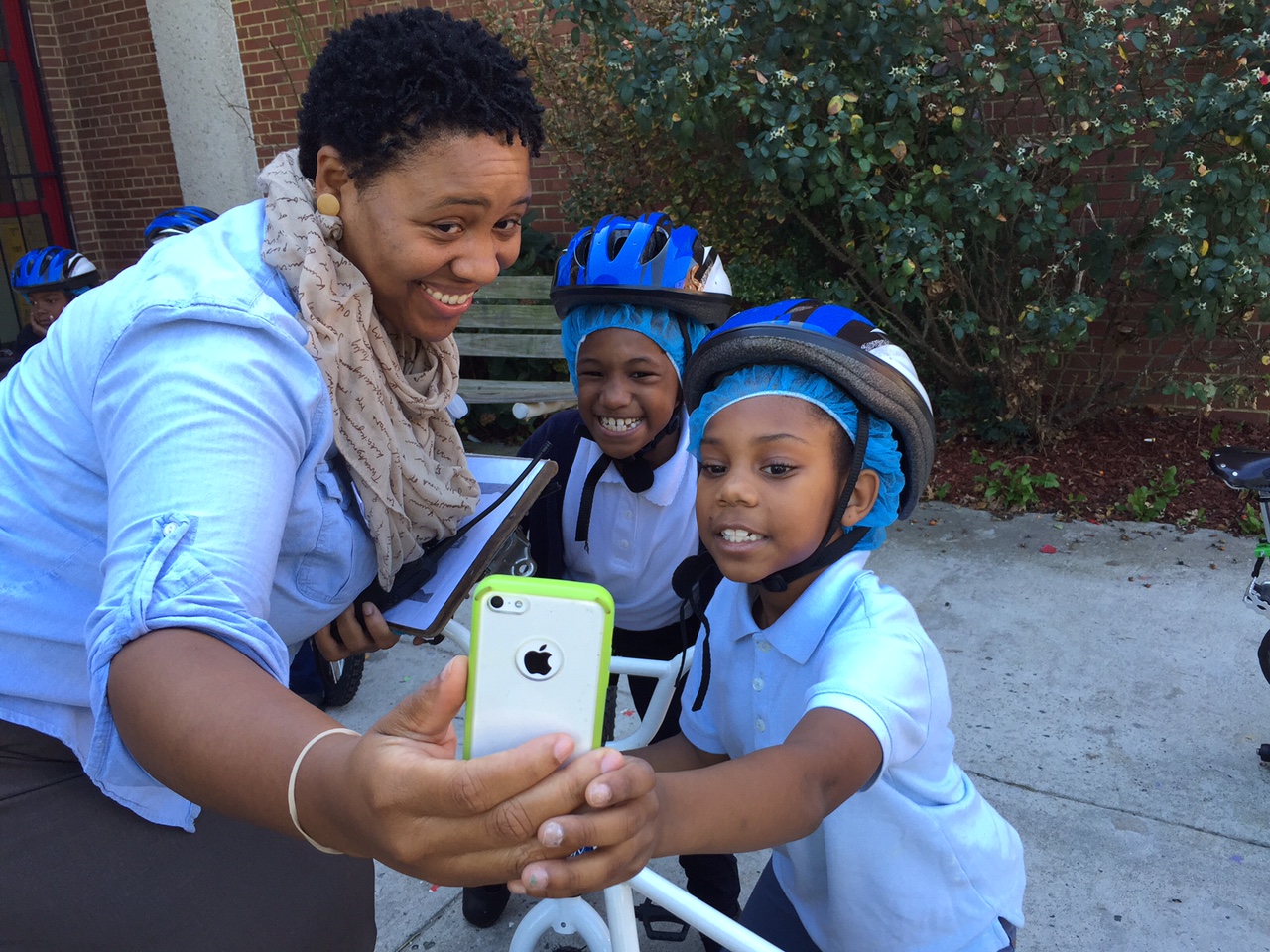 CW Harris Elementary School principal Heather Hairston takes a selfie with students before they ride. (WTOP/Kate Ryan)