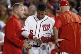 Washington Nationals' Yunel Escobar (5) points to his hand after he was hit by a pitch, as manager Matt Williams stands at right, during the fifth inning of a baseball game against the San Diego Padres at Nationals Park, Thursday, Aug. 27, 2015, in Washington. Escobar did not take the field for the next inning. (AP Photo/Alex Brandon)