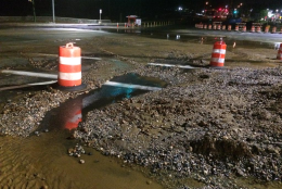 In this file photo, water and debris cover the street at Rockville Pike and Cedar Lane after a water main burst in October. Repairs to the road will begin Tuesday, Dec. 1. (WTOP/Nick Iannelli)