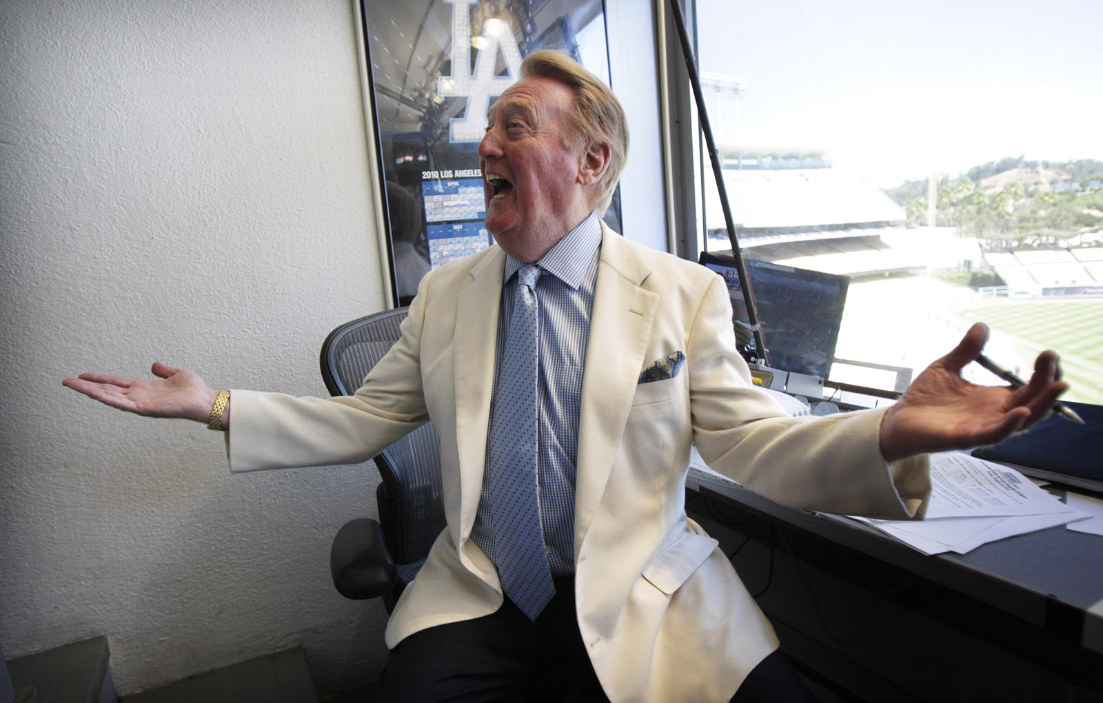 Vin Scully talks to a well-wisher in his booth at Dodger Stadium in Los Angeles, Sunday, Aug. 22, 2010. Scully will return to the broadcast booth to call Los Angeles Dodgers games next year for his 62nd season. The team said Sunday that the 82-year-old Hall-of-Famer will call all home games and road games against National League West opponents. (AP Photo/Jae C. Hong)