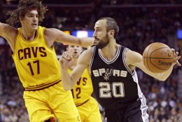 San Antonio Spurs' Manu Ginobili (20), from Argentina, drives past Cleveland Cavaliers' Anderson Varejao (17), from Brazil, during an NBA basketball game Wednesday, Nov. 19, 2014, in Cleveland. (AP Photo/Tony Dejak)