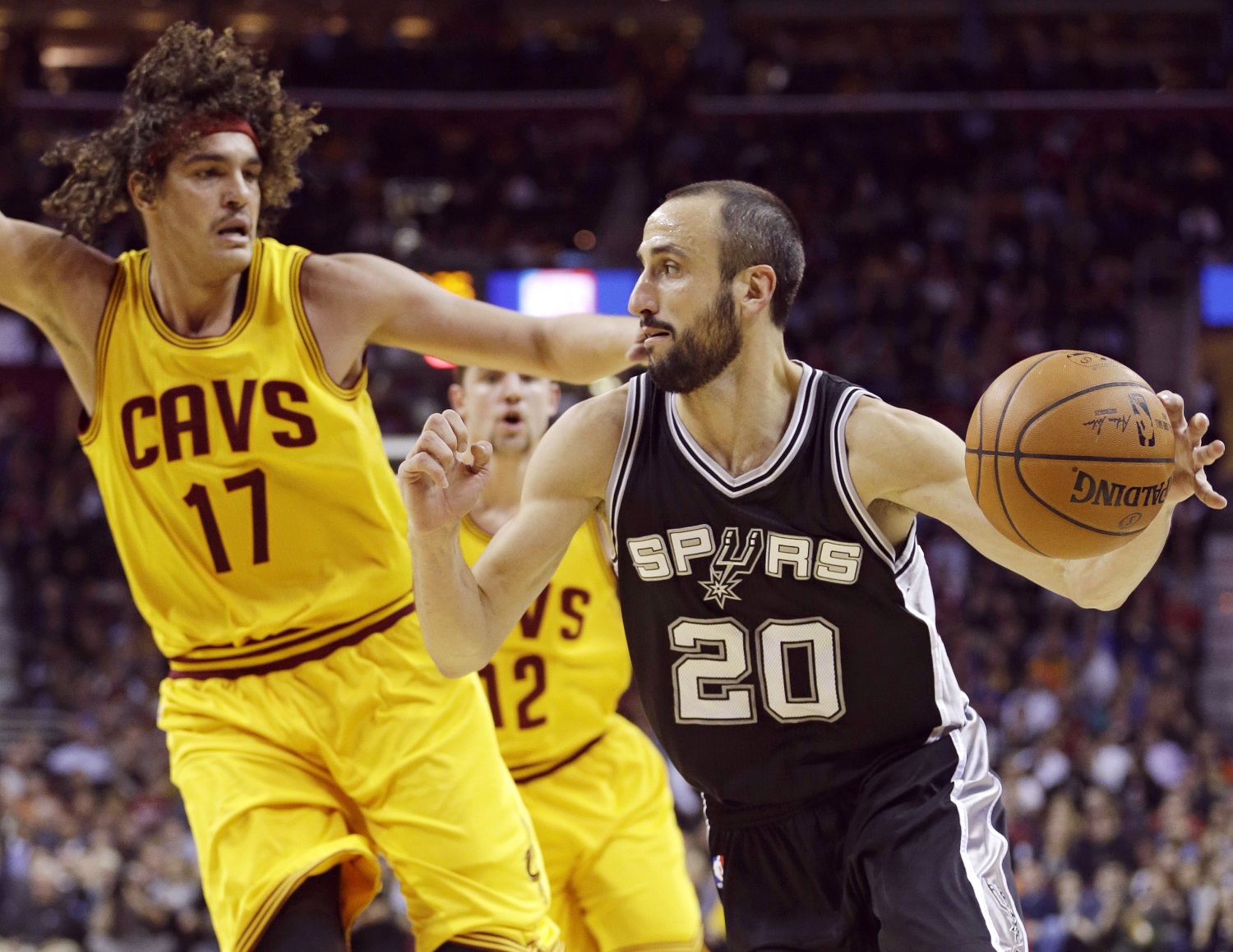 San Antonio Spurs' Manu Ginobili (20), from Argentina, drives past Cleveland Cavaliers' Anderson Varejao (17), from Brazil, during an NBA basketball game Wednesday, Nov. 19, 2014, in Cleveland. (AP Photo/Tony Dejak)