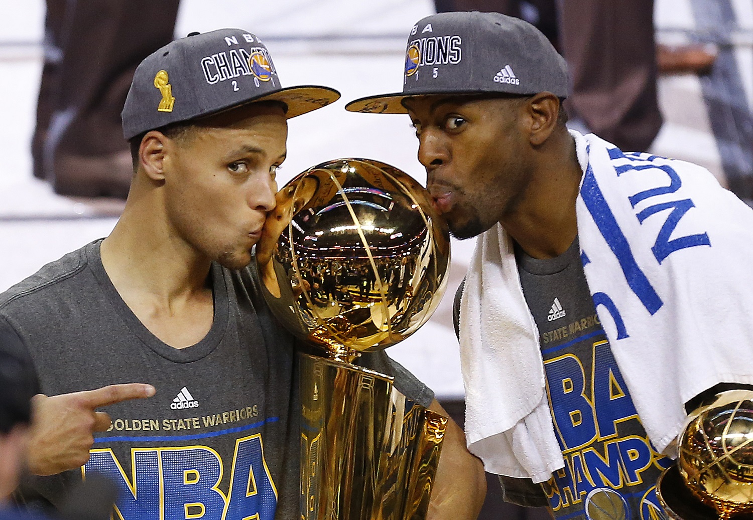 FILE - In this June 17, 2015, file photo, Golden State Warriors Stephen Curry, left, and Andre Iguodala kiss with the Larry O'Brien Trophy after defeating the Cleveland Cavaliers 105-7 in Game 6 of basketball's NBA Finals in Cleveland. NBA players James Harden and Anthony Davis checked right away to see their rating in a video game. Soon enough they can see how their teams rate in the NBA's Western Conference, where Stephen Curry's Golden State Warriors are the champs.  (AP Photo/Paul Sancya, File)