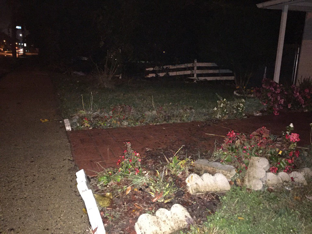 The car plowed through this yard, taking out the wooden fence in the background, before hitting the house. (WTOP/Kristi King)