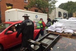 Volunteers hand out sand bags in Old Town Alexandria. Around 3000 bags were handed out today. (WTOP/Mike Murillo)