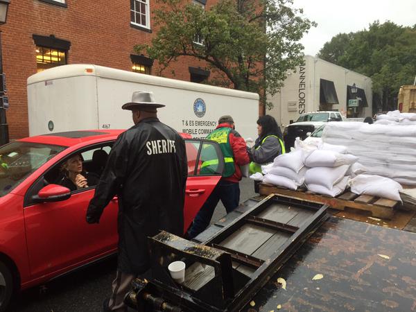 Volunteers hand out sand bags in Old Town Alexandria. Around 3000 bags were handed out today. (WTOP/Mike Murillo)