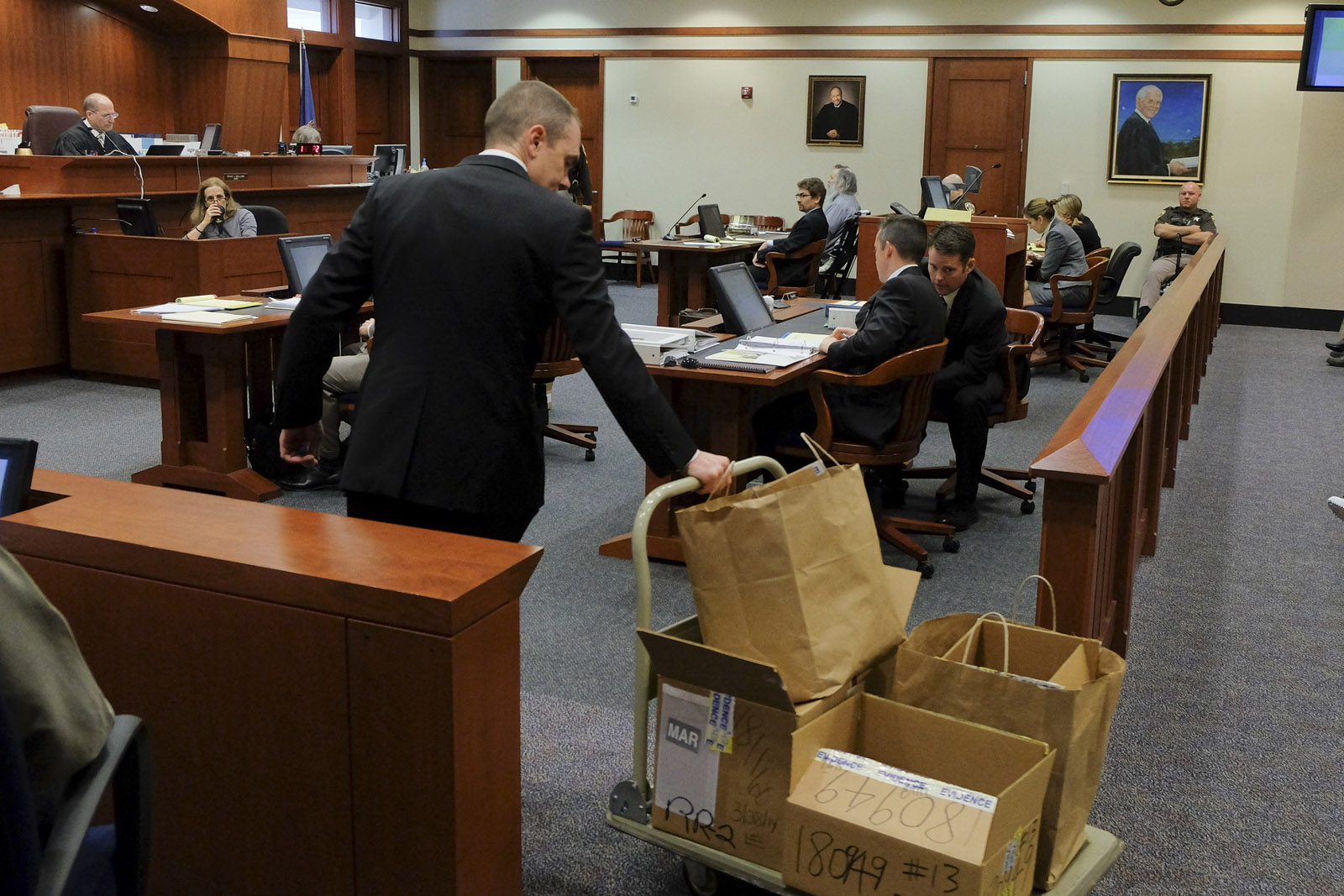 Defense attorney Chris Leibig wheels a cart of evidence to the front of the courtroom at the trial for alleged Alexandria serial killer Charles Severance at the Fairfax County Circuit Court on Wednesday, October 14, 2015.  He is accused of three murders over a 12 year period, believed to be revenge against the Alexandria court system and the citizens of the city.  
(Pool Photo by Jahi Chikwendiu/The Washington Post)