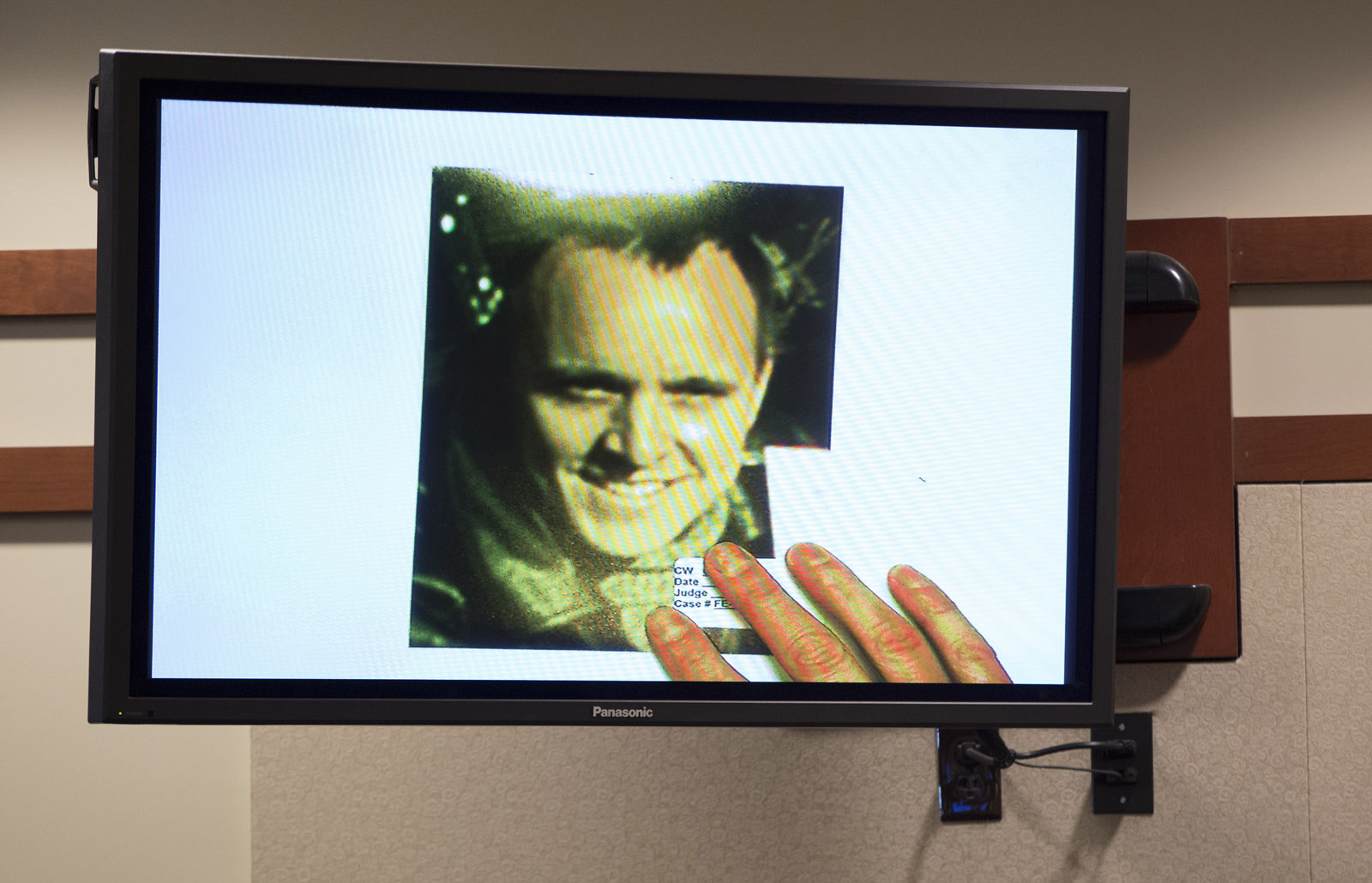An old photo of Charles Severance is shown on a monitor during his murder trial at the Fairfax County Circuit Court in Fairfax, Va., Friday, Oct. 16, 2015. The FBI used this and other known images of Severance to compare them against surveillance footage taken at the Potomac Yards Target in the hours before Nancy Dunning was murdered in 2003. (AP Photo/Evan Vucci, Pool)