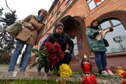 People place flowers outside the French embassy in Minsk on November 14, 2015, to pay tribute to the victims of the deadly attacks in Paris. A wave of coordinated attacks left more than 120 dead in scenes of carnage in Paris Friday, including scores massacred by attackers shouting "Allahu akbar" during a rock concert and others in a suicide bombing near the national stadium. AFP PHOTO / MAXIM MALINOVSKY        (Photo credit should read MAXIM MALINOVSKY/AFP/Getty Images)