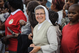 A nun waits with Kenyans to see the convoy transporting Pope Francis during his visit to Africa in Nairobi on November 25, 2015. Crowds lined Nairobi's streets to welcome the pontiff during his visit to Kenya, Uganda and the troubled Central African Republic (CAR) on a six-day trip. Vast crowds are expected to turn out to see his motorcade pass. Kenya's government has declared November 26, 2015, the first full day of his visit, in which Francis will hold a giant open air mass in central Nairobi, a public holiday and a "national day of prayer and reflection. Authorities plan to deploy over 10,000 police in the capitals of Kenya and Uganda during the pope's visit. Nairobi and Kampala are both targets for Al-Qaeda's East Africa branch, the Shebab, because they have troops deployed in Somalia. AFP PHOTO / JENNIFER HUXTA / AFP / Jennifer Huxta        (Photo credit should read JENNIFER HUXTA/AFP/Getty Images)