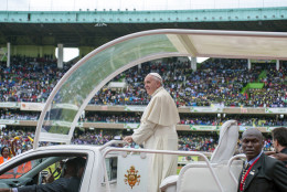 Pope Francis waves from his "Popemobile" as he arrives at the Kasarani Sport Stadium in Nairobi on November 27, 2015, as par of his six-day visit to Kenya, Uganda and Central African Republic (CAR). The pope went on to meet young people at Kasarani national stadium, where US President Barack Obama gave a keynote speech when he visited Kenya in July. AFP PHOTO/JENNIFER HUXTA / AFP / Jennifer Huxta        (Photo credit should read JENNIFER HUXTA/AFP/Getty Images)