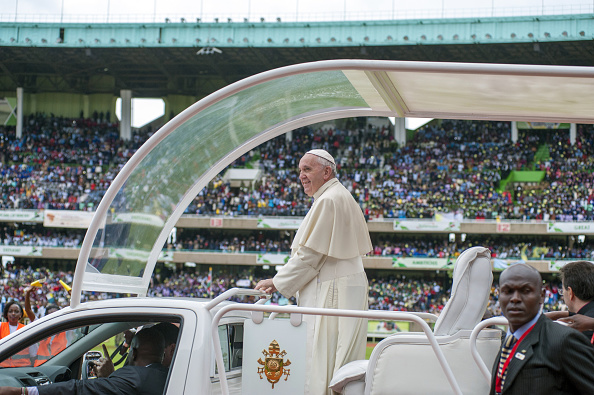 Pope Francis waves from his "Popemobile" as he arrives at the Kasarani Sport Stadium in Nairobi on November 27, 2015, as par of his six-day visit to Kenya, Uganda and Central African Republic (CAR). The pope went on to meet young people at Kasarani national stadium, where US President Barack Obama gave a keynote speech when he visited Kenya in July. AFP PHOTO/JENNIFER HUXTA / AFP / Jennifer Huxta        (Photo credit should read JENNIFER HUXTA/AFP/Getty Images)