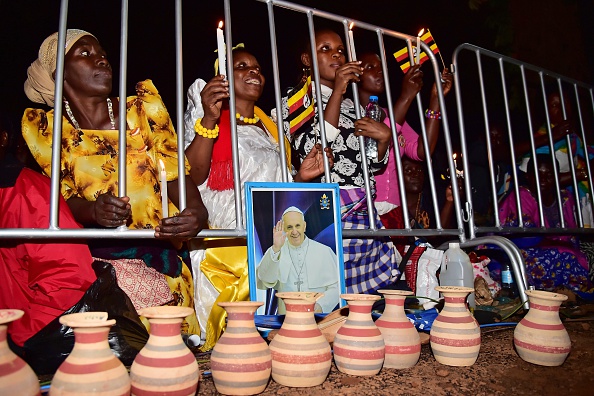 People cheer during a visit by Pope Francis with the Munyonyo community on November 27, 2015 in Kampala. Pope Francis arrived in Uganda on November 27 on the second leg of a landmark trip to Africa which has seen him railing against corruption and poverty, with huge crowds celebrating his arrival. AFP PHOTO / GIUSEPPE CACACE / AFP / GIUSEPPE CACACE        (Photo credit should read GIUSEPPE CACACE/AFP/Getty Images)