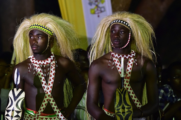 Men dressed in traditional clothes during a visit by Pope Francis with the Munyonyo community on November 27, 2015 in Kampala. Pope Francis arrived in Uganda on November 27 on the second leg of a landmark trip to Africa which has seen him railing against corruption and poverty, with huge crowds celebrating his arrival. AFP PHOTO / GIUSEPPE CACACE / AFP / GIUSEPPE CACACE        (Photo credit should read GIUSEPPE CACACE/AFP/Getty Images)