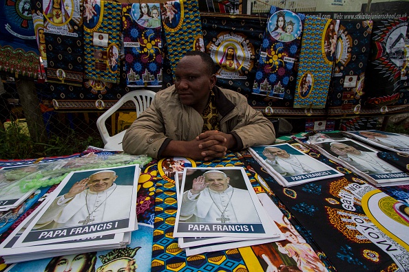 A man sells African fabrics and portraits of Pope Francis outside the Namugongo Catholic shrine in Namugongo on November 28, 2015, where the pontiff is slated to hold a mass. AFP PHOTO/ ISAAC KASAMANI / AFP / ISAAC KASAMANI        (Photo credit should read ISAAC KASAMANI/AFP/Getty Images)