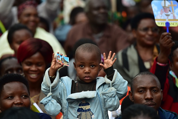 A child gestures as people wait for the arrival of Pope Francis for an open mass in  Kampala, Uganda, November 28, 2015. Pope Francis arrived in Uganda on November 27 on the second leg of a landmark trip to Africa which has seen him railing against corruption and poverty, with huge crowds celebrating his arrival. AFP PHOTO / GIUSEPPE CACACE / AFP / GIUSEPPE CACACE        (Photo credit should read GIUSEPPE CACACE/AFP/Getty Images)
