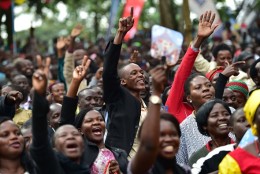 People react as they wait for the arrival of Pope Francis for an open mass in  Kampala, Uganda, November 28, 2015. Pope Francis arrived in Uganda on November 27 on the second leg of a landmark trip to Africa which has seen him railing against corruption and poverty, with huge crowds celebrating his arrival. AFP PHOTO / GIUSEPPE CACACE / AFP / GIUSEPPE CACACE        (Photo credit should read GIUSEPPE CACACE/AFP/Getty Images)