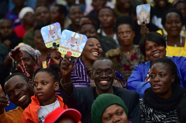 A believer holds a picture of Pope Francis as people wait for the arrival of the pope for an open mass in  Kampala, Uganda, November 28, 2015. Pope Francis arrived in Uganda on November 27 on the second leg of a landmark trip to Africa which has seen him railing against corruption and poverty, with huge crowds celebrating his arrival. AFP PHOTO / GIUSEPPE CACACE / AFP / GIUSEPPE CACACE        (Photo credit should read GIUSEPPE CACACE/AFP/Getty Images)