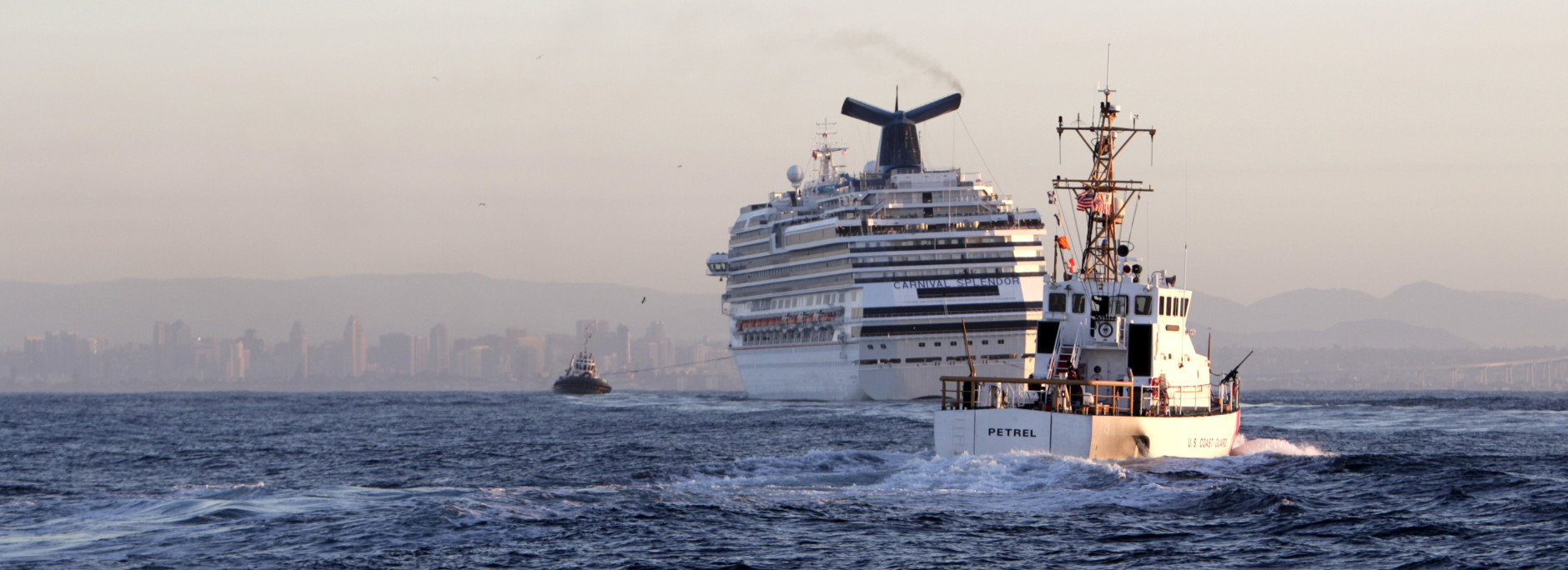 Tugboats bring the disabled cruise ship Carnival Splendor to dock in San Diego, seen in the background, on Thursday, Nov. 11, 2010. (AP Photo/Lenny Ignelzi)
