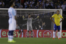 Brazil's goalkeeper Alisson, center, defender Miranda, right, and Argentina's Ezequiel Lavezzi observe a minute of silence to pay respect to the victims of the Paris attacks prior to a 2018 World Cup qualifying soccer match in Buenos Aires, Argentina, Friday, Nov. 13, 2015. Several dozen people were killed in attacks around Paris on Friday, French President Francois Hollande said, announcing that he was closing the countrys borders and declaring a state of emergency. (AP Photo/Victor R. Caivano)
