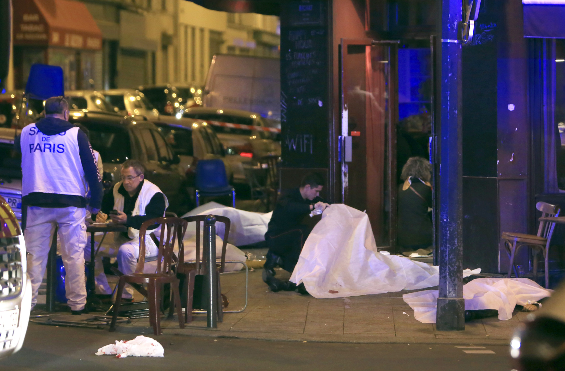 RETRANSMISSION FOR ALTERNATIVE CROP - Victims lay on the pavement outside a Paris restaurant, Friday, Nov. 13, 2015.  Police officials in France on Friday report multiple terror incidents, leaving many dead.  It was unclear at this stage if the events are linked. (AP Photo/Thibault Camus)