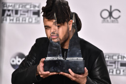The Weeknd poses in the press room with the awards for best soul/R&amp;B male artist and favorite album - soul/R&amp;B at the American Music Awards at the Microsoft Theater on Sunday, Nov. 22, 2015, in Los Angeles. (Photo by Jordan Strauss/Invision/AP)