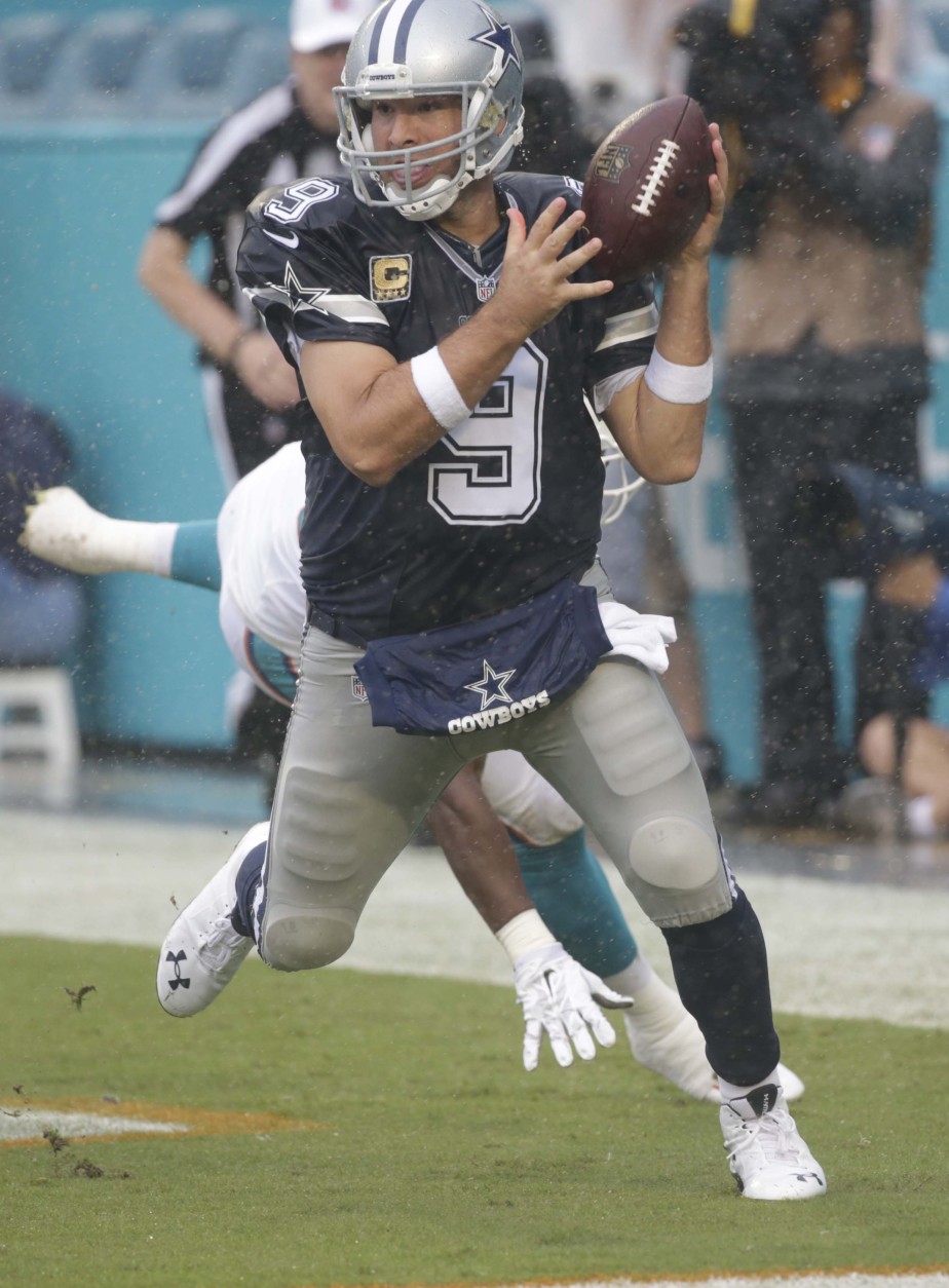 Dallas Cowboys quarterback Tony Romo (9) prepares to throw with his left hand as he scrambles in the end zone during the first half of an NFL football game against the Miami Dolphins, Sunday, Nov. 22, 2015, in Miami Gardens, Fla. The Cowboys defeated the Dolphins 24-14.  (AP Photo/Wilfredo Lee)