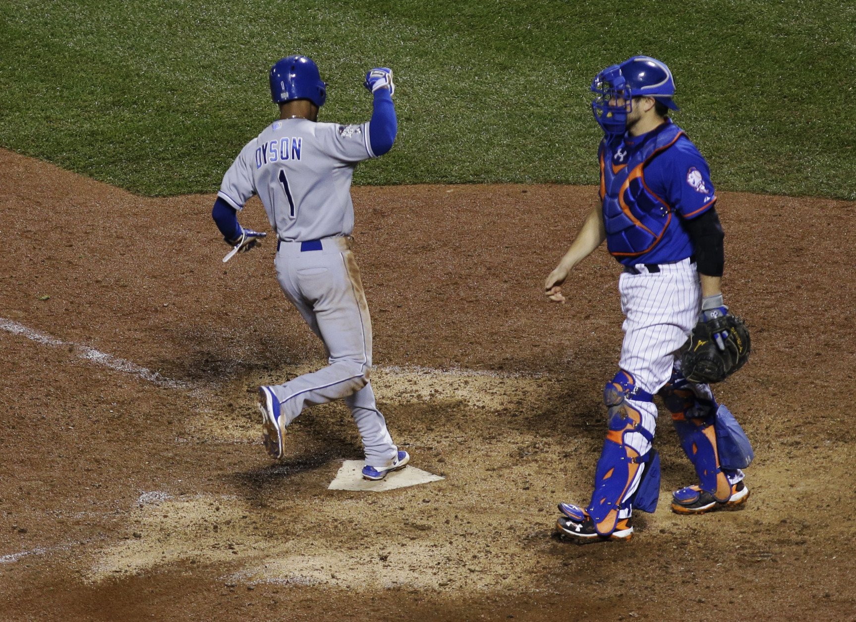 New York Mets catcher Travis d'Arnaud watches Kansas City Royals' Jarrod Dyson celebrates after scoring on an RBI single by Christian Colon during the 12th inning of Game 5 of the Major League Baseball World Series Monday, Nov. 2, 2015, in New York. (AP Photo/Matt Slocum)