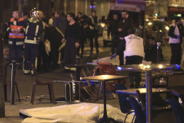 RETRANSMISSION FOR ALTERNATIVE CROP - Emergency services attewnd the scene as victims lay on the pavement outside a Paris restaurant, Friday, Nov. 13, 2015.  Police officials in France on Friday report multiple terror incidents, leaving many dead.  It was unclear at this stage if the events are linked. (AP Photo/Thibault Camus)