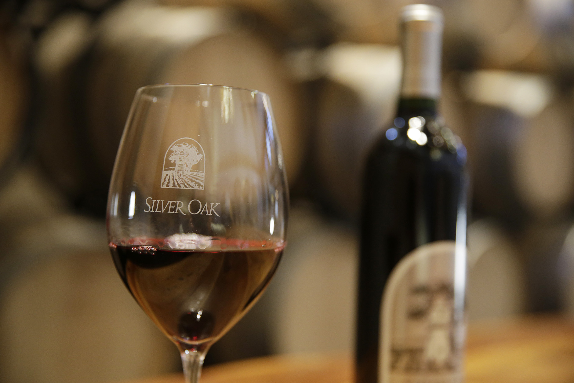 This Tuesday, March 3, 2015 photo shows a glass of Cabernet Sauvignon wine in front of American Oak barrels on display at Silver Oak Cellars in Oakville, Calif. (AP Photo/Eric Risberg)