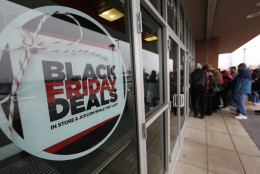 A sign promoting Black Friday specials is displayed in the window of a J.C. Penny store as shoppers queue up at the door for a 3 p.m. opening, Thursday, Nov. 26, 2015, in northeast Denver. The store opened two hours before other retailers to cash in on a flurry of bargain hunters, some who said that they waited for three hours to be one of the first people queued up outside. (AP Photo/David Zalubowski)