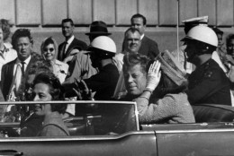 President John F. Kennedy is seen riding in motorcade approximately one minute before he was shot in Dallas, Tx., on Nov. 22, 1963.  In the car riding with Kennedy are Mrs. Jacqueline Kennedy, right, Nellie Connally, left, and her husband, Gov. John Connally of Texas.  (AP Photo/Jim Altgens)