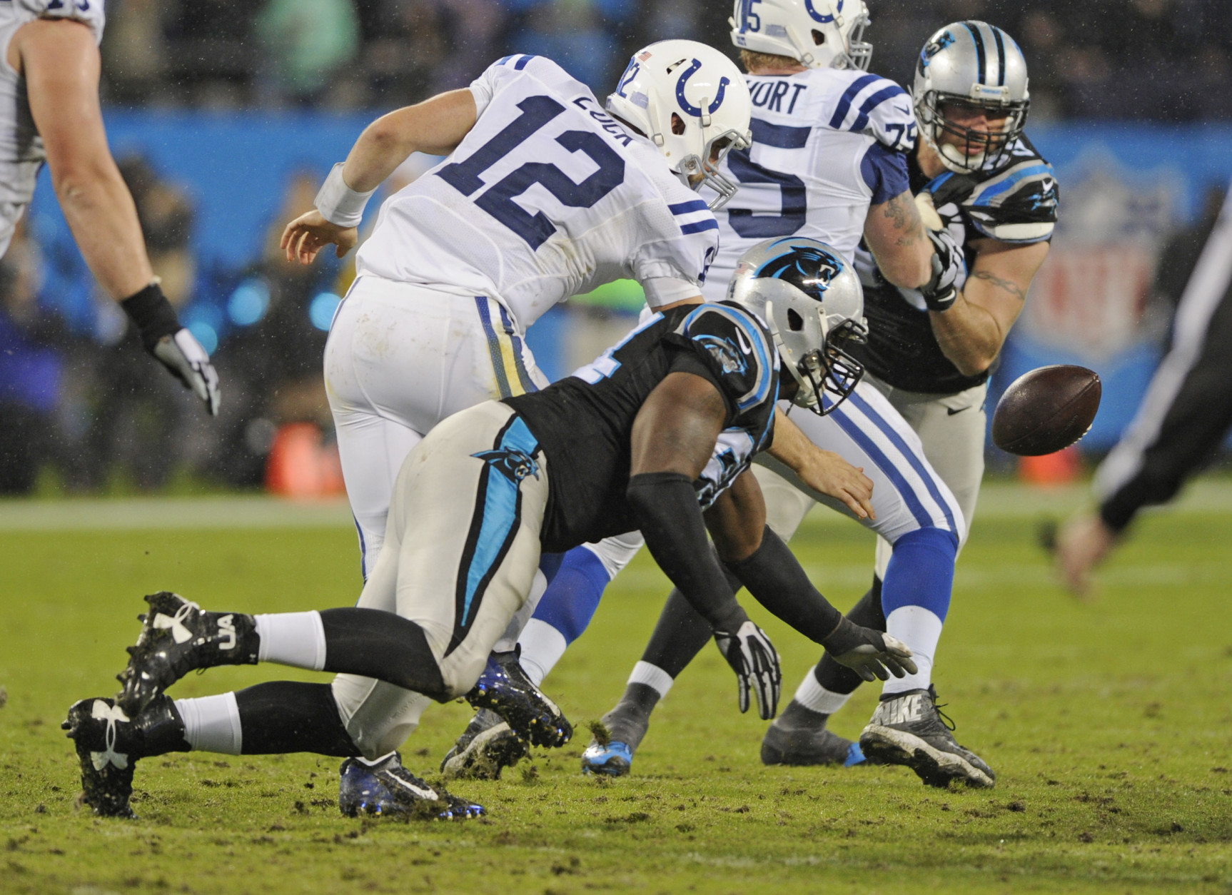 Indianapolis Colts' Andrew Luck (12) fumbles the ball after being hit by Carolina Panthers' Kony Ealy (94) in the first half of an NFL football game in Charlotte, N.C., Monday, Nov. 2, 2015. The Colts recovered the fumble. (AP Photo/Mike McCarn)