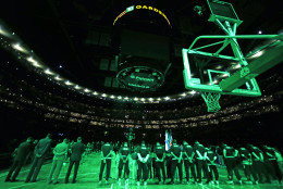 The house lights are shut off and scoreboard dark as the Boston Celtics pause for a moment of silence for the victims of shooting and bombing attacks in Paris prior to an NBA basketball game against the Atlanta Hawks in Boston, Friday, Nov. 13, 2015.(AP Photo/Charles Krupa)
