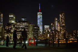 The One World Trade Center spire is lit blue, white and red after New York Gov. Andrew Cuomo announced the lighting in honor of dozens killed in the Paris attacks Friday, Nov. 13, 2015, in New York. French officials say several dozen people have been killed in shootings and explosions at a theater, restaurant and elsewhere in Paris. (AP Photo/Kevin Hagen)