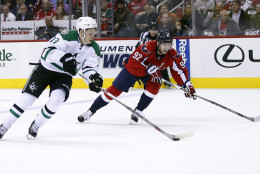Dallas Stars center Mattias Janmark (13), from Sweden, skates with the puck as Washington Capitals center Evgeny Kuznetsov (92), from Russia, defends during the second period of an NHL hockey game, Thursday, Nov. 19, 2015, in Washington. (AP Photo/Alex Brandon)
