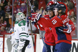Washington Capitals left wing Alex Ovechkin (8), from Russia, celebrates with center Nicklas Backstrom (19), from Sweden, after Backstrom's goal past Dallas Stars goalie Kari Lehtonen (32), from Finland, during the first period of an NHL hockey game, Thursday, Nov. 19, 2015, in Washington. (AP Photo/Alex Brandon)