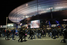 People leave the Stade de France stadium after the international friendly soccer France against Germany, Friday, Nov. 13, 2015 in Saint Denis, outside Paris. Two police officials say at least 11 people have been killed in shootouts and other violence around Paris. Police have reported shootouts in at least two restaurants in Paris. At least two explosions have been heard near the Stade de France stadium, and French media is reporting of a hostage-taking in the capital. (AP Photo/Michel Euler)