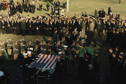 Honor Guards remove the U.S. flag from the coffin of President John F. Kennedy during funeral services at Arlington National Cemetery, Arlington, Va., Nov. 25, 1963. The late president's widow Jacqueline Kennedy and other members of the family look on. (AP Photo)