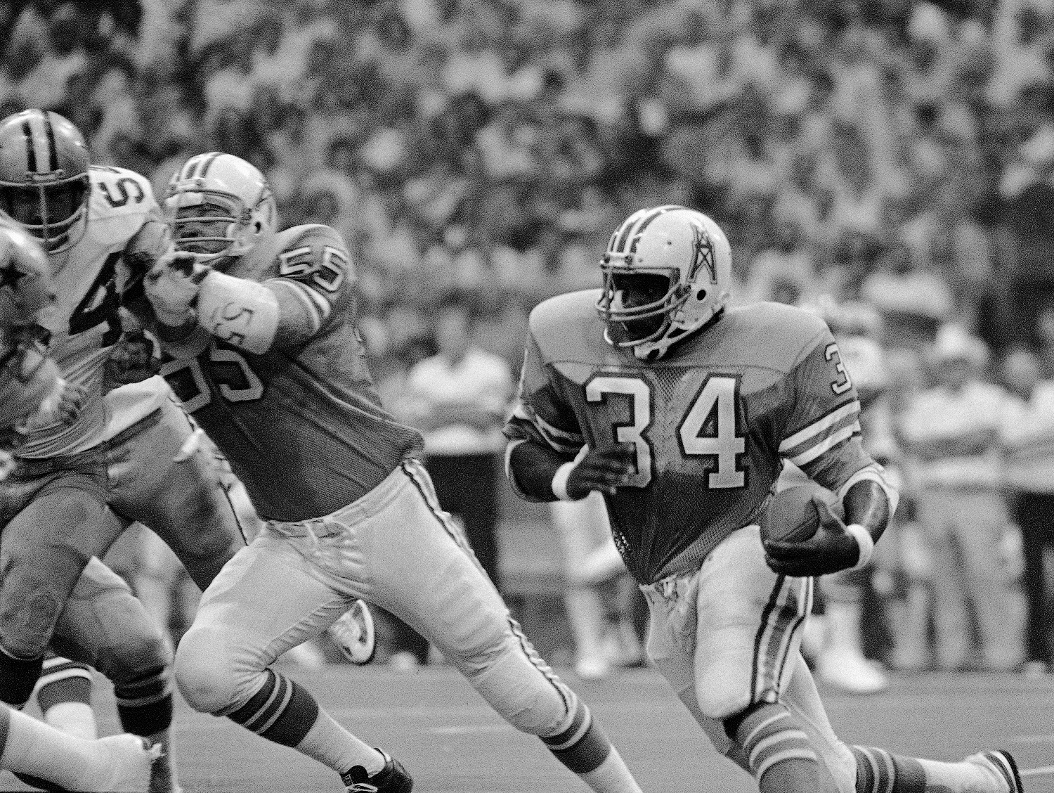Houston Oilers star running back Earl Campbell (34) shown in action during Saturday night, Aug. 24, 1980 exhibition game against the Dallas Cowboys at Texas Stadium.  (AP Photo/Bill Haber)