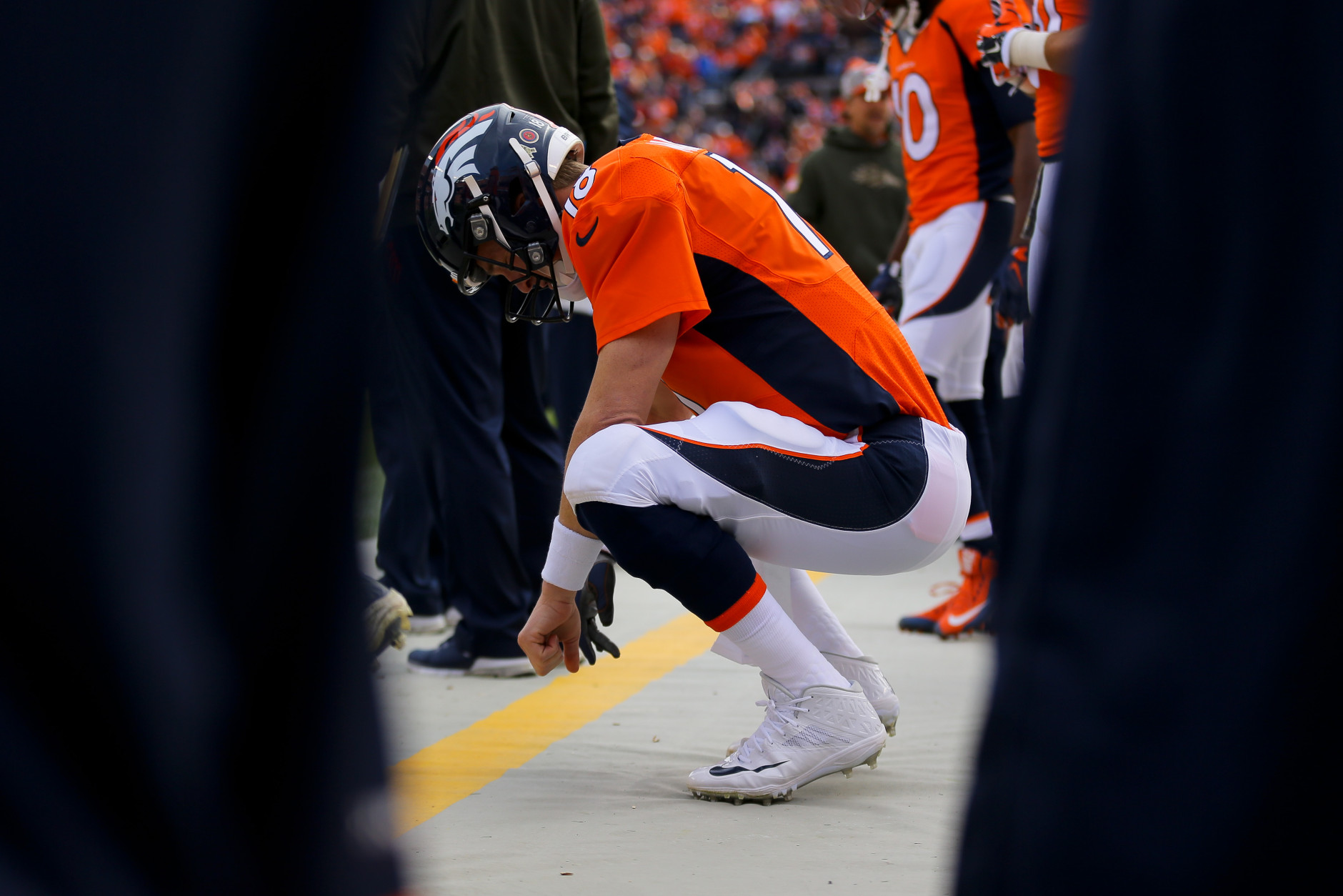 DENVER, CO - NOVEMBER 15:  Quarterback Peyton Manning #18 of the Denver Broncos crouches on the sidelines during a game against the Kansas City Chiefs at Sports Authority Field Field at Mile High on November 15, 2015 in Denver, Colorado. (Photo by Justin Edmonds/Getty Images)