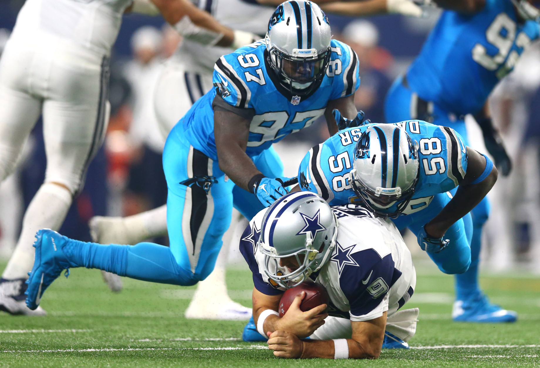 ARLINGTON, TX - NOVEMBER 26: Tony Romo #9 of the Dallas Cowboys is taken down by Thomas Davis #58 and Mario Addison #97 of the Carolina Panthers in the third quarter at AT&amp;T Stadium on November 26, 2015 in Arlington, Texas. Romo left the field following the play. (Photo by Ronald Martinez/Getty Images)
