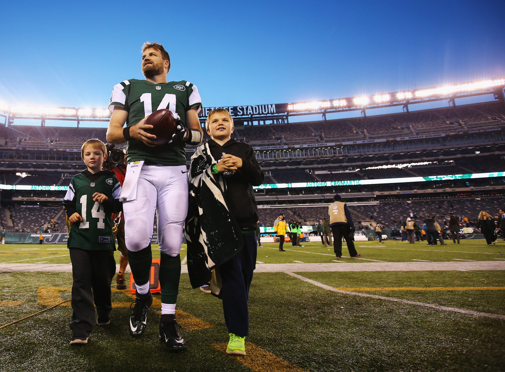 EAST RUTHERFORD, NJ - NOVEMBER 29:  Ryan Fitzpatrick #14 of the New York Jets walks off the field with his children after their 38-20 win against the Miami Dolphin at MetLife Stadium on November 29, 2015 in East Rutherford, New Jersey.  (Photo by Al Bello/Getty Images)