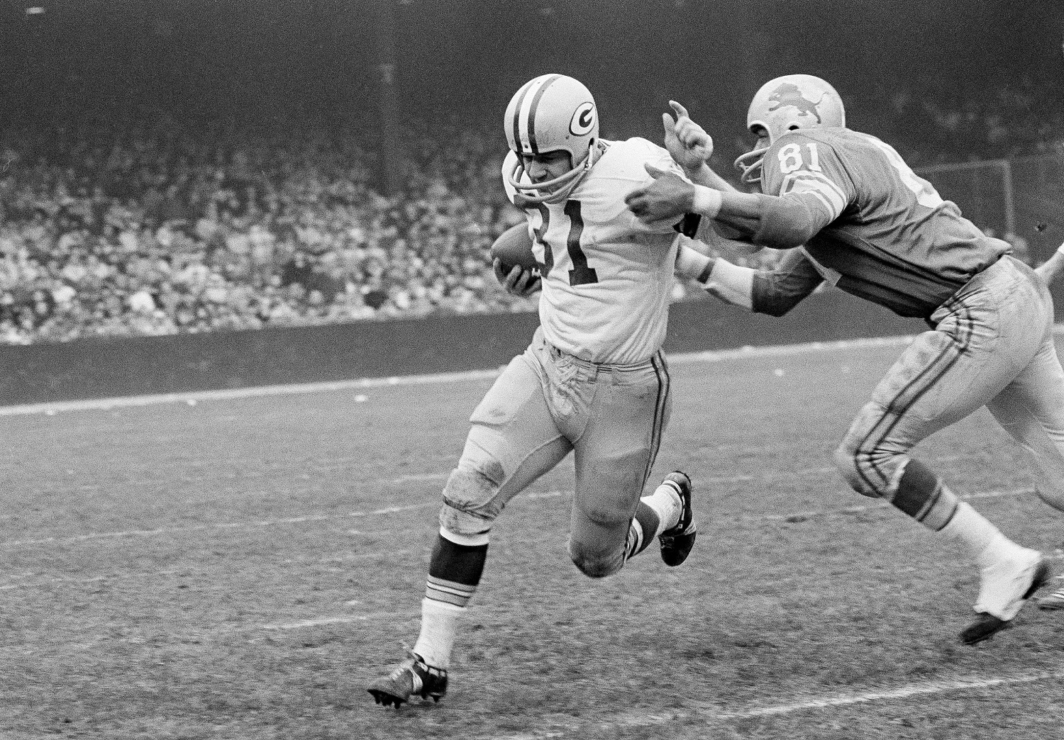 Jim Taylor (31) of the Green Bay Packers, the NFL's leading ground-gainer, is brought down by Lions' Dick Lane in the third quarter in Detroit, Nov. 22, 1962. Taylor was held to a scant 47 yards on the ground by Detroit in dumping the league's leaders 26-14. (AP Photo/Preston Stroup)